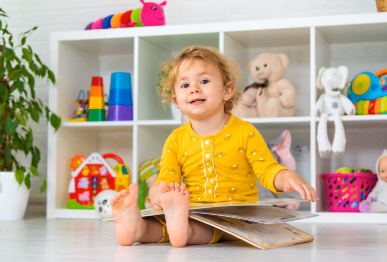 baby sitting on the floor and holding the book