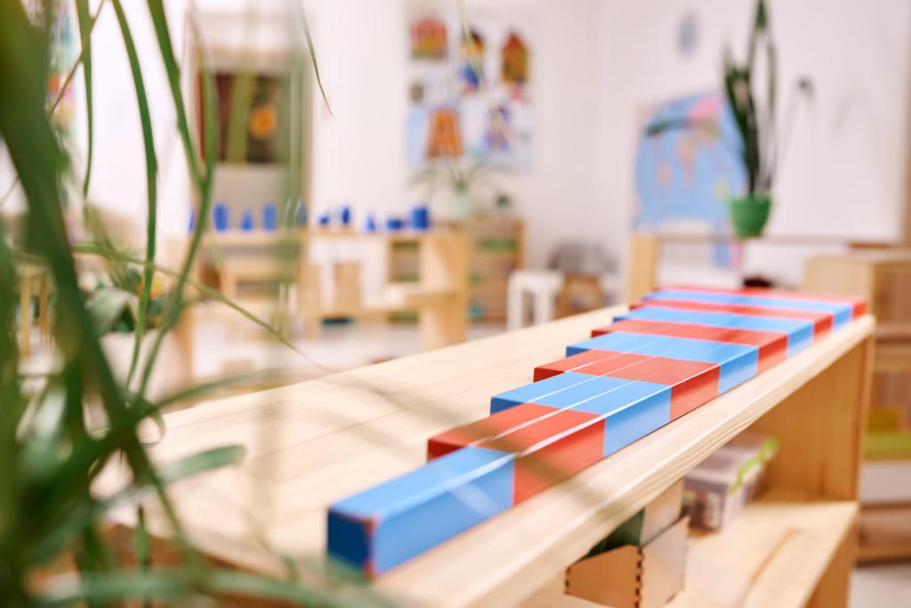 Number rods arranged on a natural wood shelf in a Montessori classroom