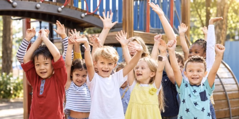A group of children with their arms raised on a playground
