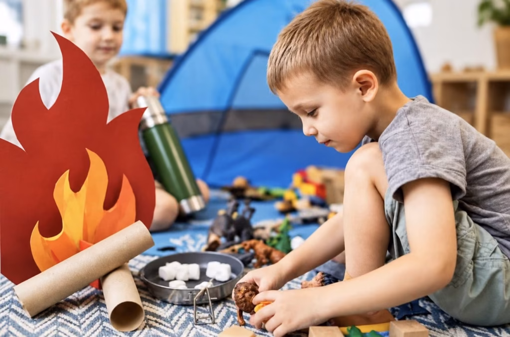 A boy playing with toy animals and a paper campfire in a classroom