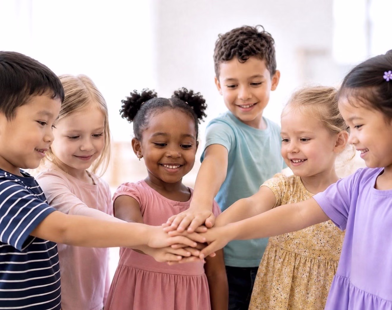 Children stacking their hands together in a circle