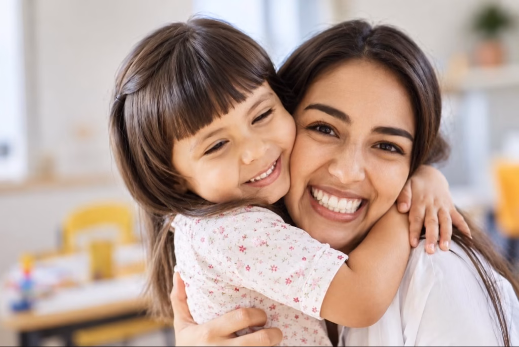 A smiling woman hugging a young girl
