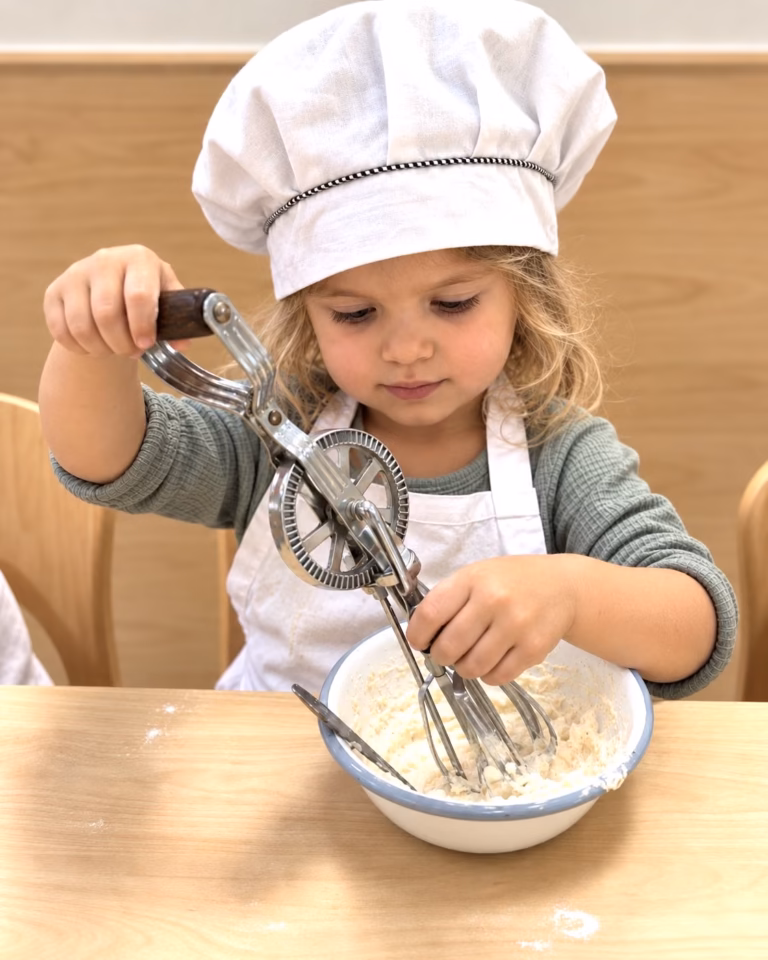 Child in a chef hat whisking batter in a bowl