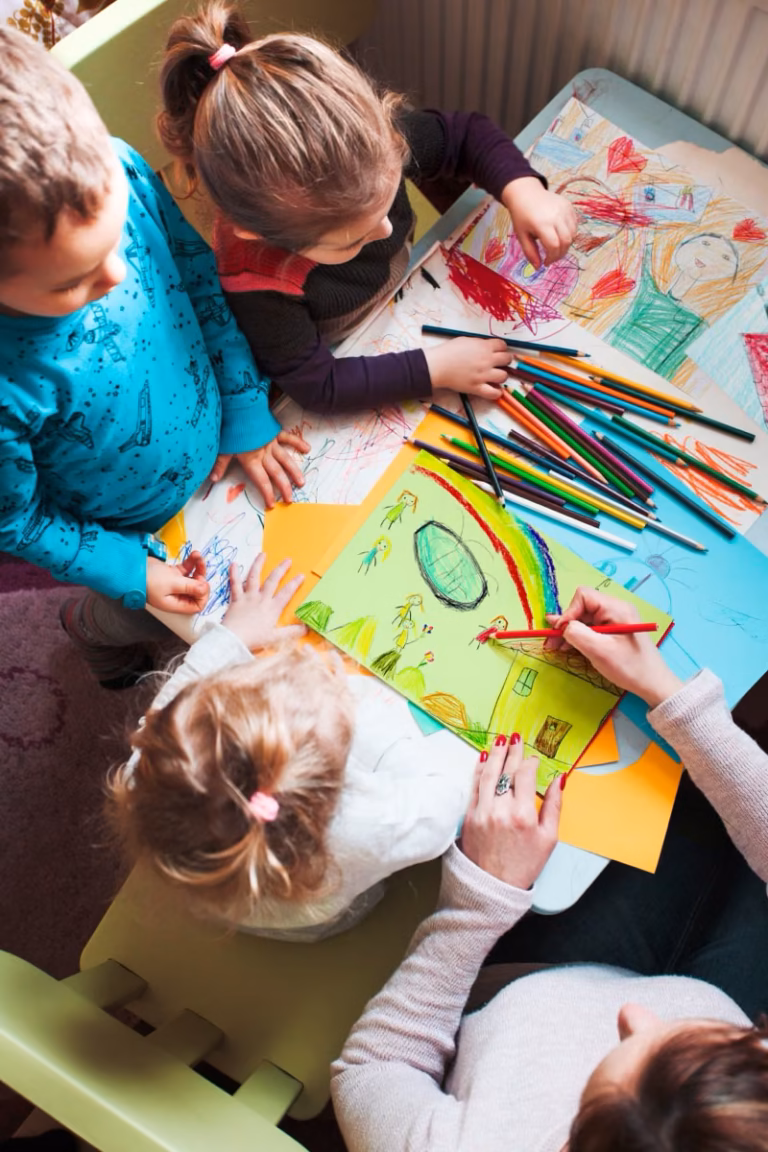 Child and adult drawing together at a table